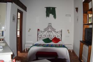 una camera da letto con un letto con cuscini rossi e verdi di Apartamentos Carmen de Ramilla a Granada