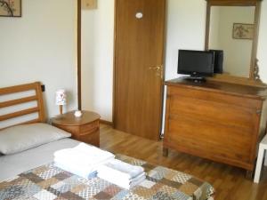 a bedroom with a bed and a tv on a dresser at Villino Arcola in Arcola