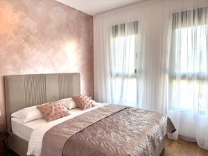 a bedroom with a bed with pink walls and windows at Apartment BAR M3A sea view in Bar +25 photos