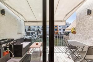 a balcony with a couch and a table and chairs at Port Empúries in Empuriabrava