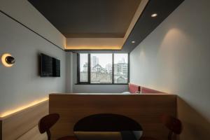 a waiting room with a table and chairs and a window at SFEEL设计师酒店Designer Hotel乐山大佛上中顺店 in Leshan
