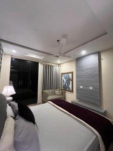 a bedroom with a large bed and a couch at Dreamy 2 BHK Escape Near Airport DHA PH 8 in Dargai