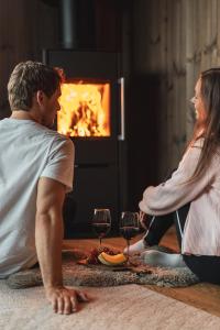 a man and a woman sitting on the floor with wine glasses at Nordic Luxury Apartment - Private Sauna & Panoramic Mountain Views in Stranda +25 photos