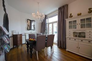 a dining room with a table and chairs and a chandelier at SunnyBeach Luxury apartment in Zandvoort