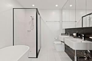 a white bathroom with two sinks and a shower at Big Two-Story with Private Elevator & Balconies in Sydney