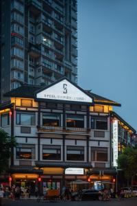 a building with a sign on it in front of a tall building at SFEEL设计师酒店Designer Hotel乐山大佛上中顺店 in Leshan