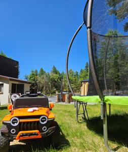an orange vehicle is parked next to a hoop at Leśne zacisze - dom z kominkiem i balią in Jordanów