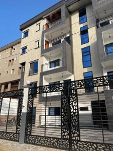 an apartment building with a gate in front of it at Maison Royale in Kofa
