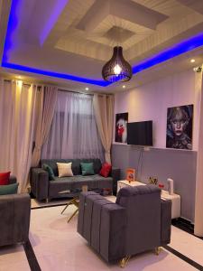 a living room with blue lights on the ceiling at Maison Royale in Kofa