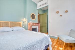 a bedroom with a bed and a chair and a fireplace at Appartement Climatisé, 2 personnes in Eymet