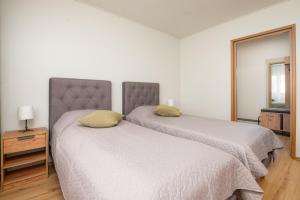 パルヌにあるPapiniidu Apartmentの白いベッドルーム(ベッド2台、テレビ付)