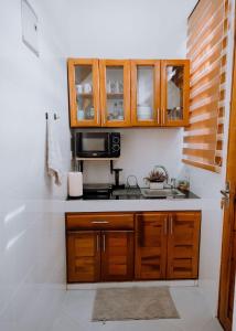 a kitchen with a sink and a microwave at Magnolia Homes Tz in Nkunjila