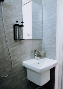 a white sink in a bathroom with a shower at Magnolia Homes Tz in Nkunjila