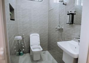 een kleine badkamer met toilet en wastafel bij Magnolia Homes Tz in Nkunjila +7 foto's