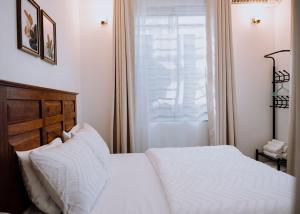 a bedroom with a white bed and a window at Magnolia Homes Tz in Nkunjila