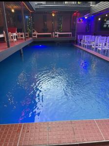 a large pool of blue water with chairs in a room at Maison Royale in Kofa