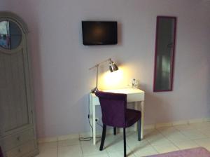 a desk with a lamp and a chair in a room at Les chambres d'hôtes au bon accueil in Limeuil