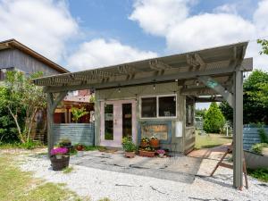 a house with a pergola in the yard at Tabist Elias Garden in Ichinomiya