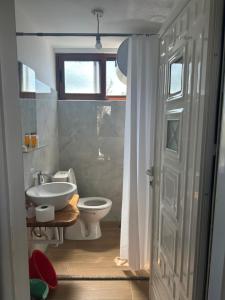 a bathroom with a sink and a toilet and a window at SEA bed and restaurant 1 in Borsh