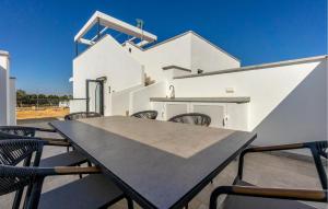 a table and chairs on a patio with a white building at Amazing Home In San Javier in San Javier