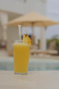 een glas sinaasappelsap met een stok erin bij Tawi Elegant Rooms - Watamu in Watamu