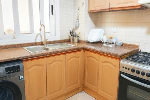 a kitchen with a sink and a stove at SPACIOUS 2BHK VACATION HOME IN DUBAI SHARJAH BORDER By MAUON COM in Sharjah +6 photos
