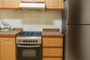 a kitchen with a stove and a refrigerator at SPACIOUS 2BHK VACATION HOME IN DUBAI SHARJAH BORDER By MAUON COM in Sharjah