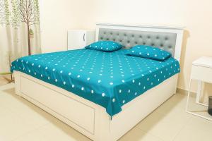 a white bed with blue sheets and blue pillows at SPACIOUS 2BHK VACATION HOME IN DUBAI SHARJAH BORDER By MAUON COM in Sharjah