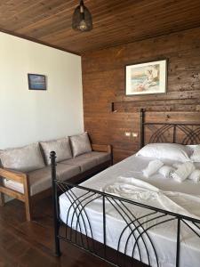 a bedroom with a bed and a couch in it at SEA bed and restaurant 2 in Borsh