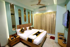 a bedroom with a bed with mirrors and a television at Hotel AR Inn in Thane