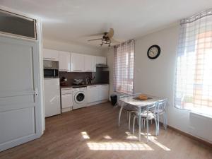 a kitchen with a table and chairs in a room at Le Repère De Charles Reboul in Marseillan