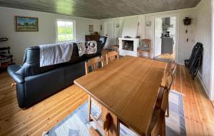 a living room with a black couch and a wooden table at 2 Bedroom Stunning Home In Burseryd in Burseryd