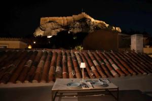 a table sitting on top of a roof at night at Acropolis Neoclassic Elegance in Athens