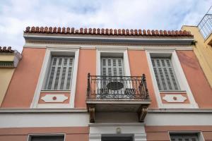 a pink building with a balcony on top of it at Acropolis Neoclassic Elegance in Athens +57 photos