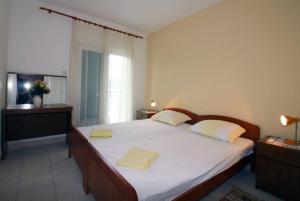 een slaapkamer met een bed met twee gele handdoeken erop bij Waterfront Apartments in Tisno