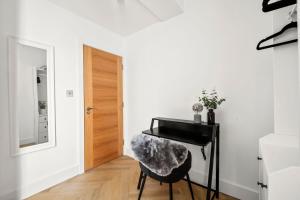 a living room with a piano and a stool at Stylish London Flat I Free parking in Harrow