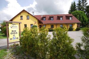 ein gelbes Haus mit einem Schild davor in der Unterkunft Penzion Lipno Jantar in Horní Planá