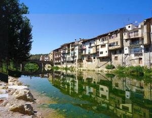 a view of a river with buildings and a bridge at Piso a orillas del río in Valderrobres