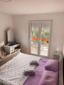 ein Schlafzimmer mit einem Bett mit zwei Handtüchern darauf in der Unterkunft Apartmani Ana S in Vrnjačka Banja