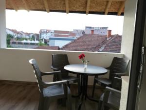 a table and chairs in a room with a window at Apartmani Ana S in Vrnjačka Banja