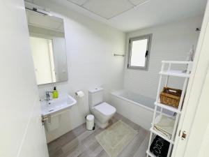 a white bathroom with a toilet and a sink at Denia - Alquiler de Piso cerca del Club Náutico in Denia +12 photos