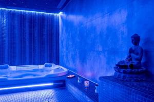 a blue room with a statue in a tub at Hotel Spa Gametxo in Ibarrangelu