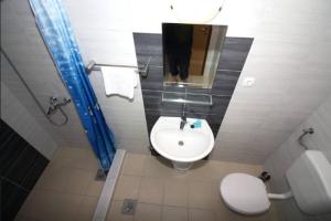 a bathroom with a white sink and a toilet at Waterfront Apartments in Tisno