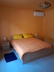 una camera da letto con un letto grande con cuscini gialli di Au bord du Rhône a Tain-l'Hermitage