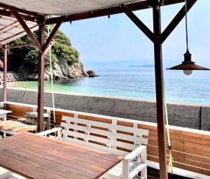 a wooden table with a view of the ocean at プチリゾート・ひじきwest in Hijiki
