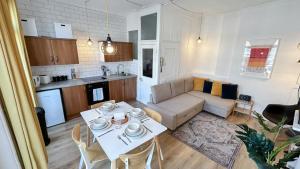 a kitchen and living room with a table and a couch at Stylish 2-Bedroom Flat in Barbican Centre near Farringdon with Rooftop Terrace in London