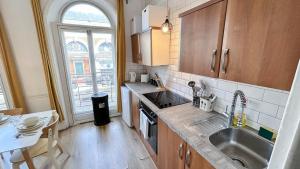 a small kitchen with a sink and a window at Stylish 2-Bedroom Flat in Barbican Centre near Farringdon with Rooftop Terrace in London