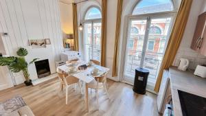 a living room with a table and chairs and a fireplace at Stylish 2-Bedroom Flat in Barbican Centre near Farringdon with Rooftop Terrace in London