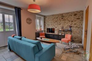 a living room with a blue couch and orange chairs at La ville es brets in Saint-Jouan-des-Guérets