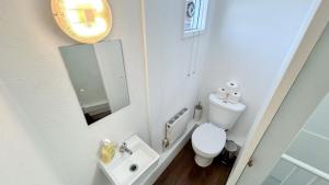 a small bathroom with a toilet and a sink at Stylish 2-Bedroom Flat in Barbican Centre near Farringdon with Rooftop Terrace in London